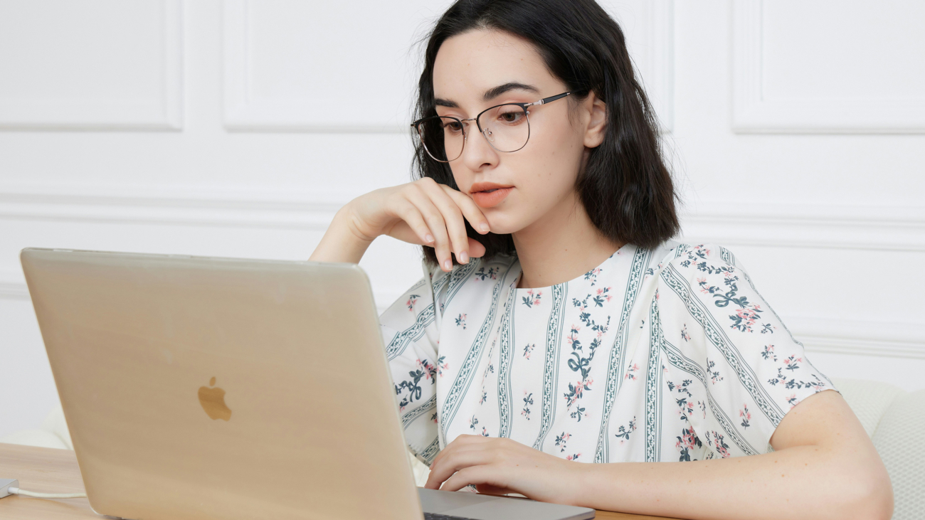 Entrepreneure sensible devant son PC, qui essaie de suivre un modèle d'organisation classique d'entrepreneur