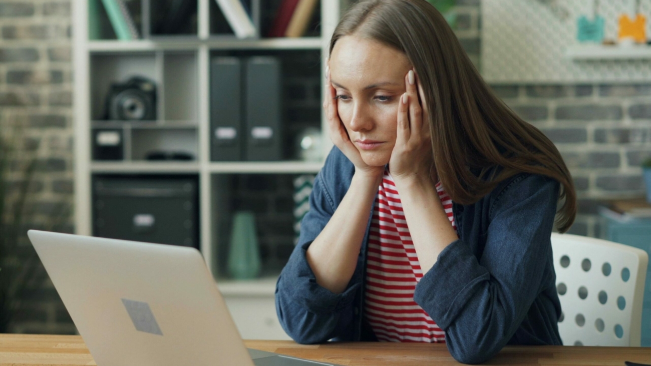 Femme devant son PC la tête dans les mains, illustrant la lassitude