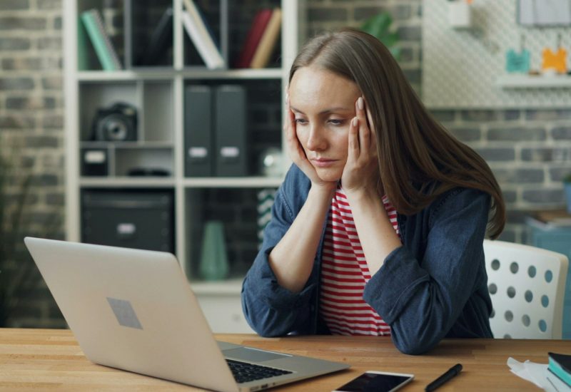 Femme devant son PC la tête dans les mains, illustrant la lassitude